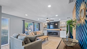 A modern living room with a grey sofa, wooden coffee table, and a decorative bowl on a table.