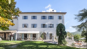 A large, white building with multiple windows and a covered outdoor seating area. - Villa Cappelletti 16+2, Emma Villas (Corgneto)