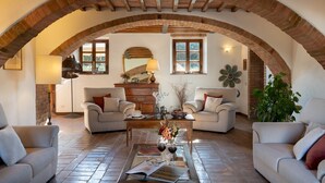A cozy living room with two sofas, a coffee table, and a fireplace.