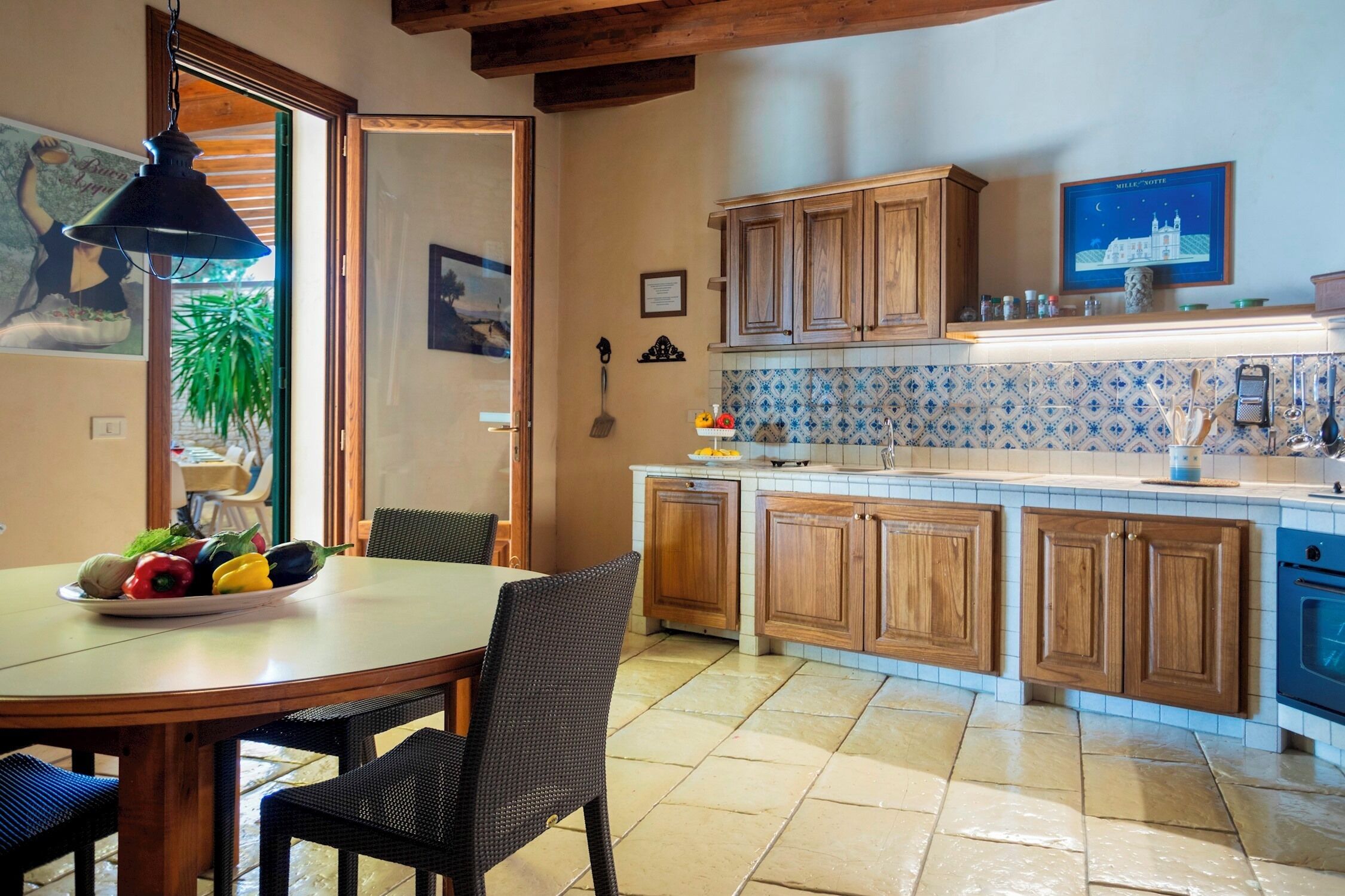 A kitchen with wooden cabinets, a tiled backsplash, and a dining area with a table and chairs.