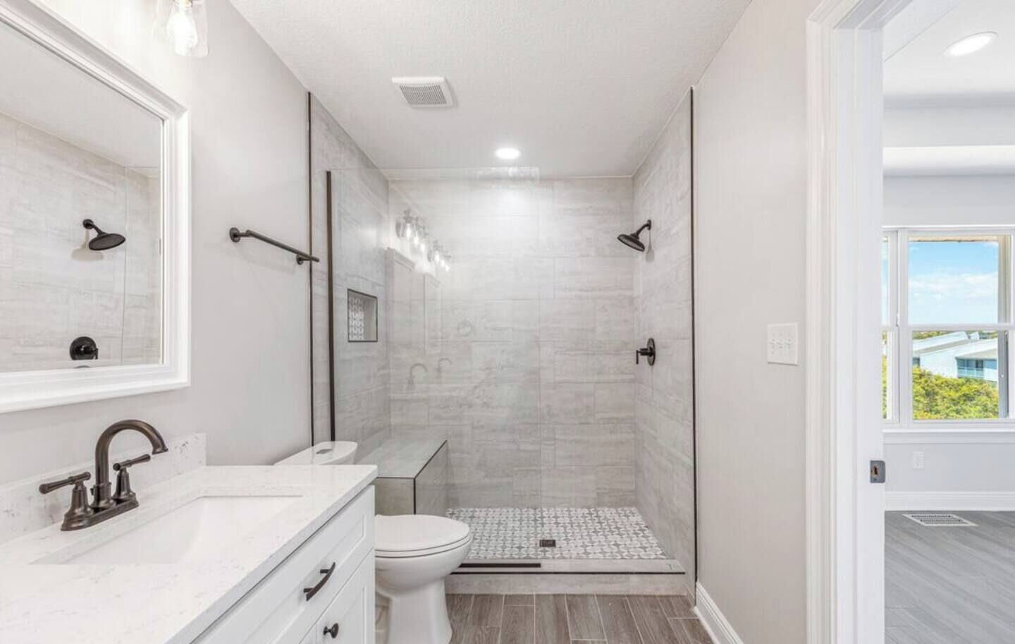 A modern bathroom with a shower, toilet, and vanity.
