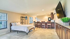 A bedroom with a bed, a dining area with chairs, a kitchen with a TV, and a large window. - On-Site Pond: Sleek Largo Studio < 7 Mi to Beach! (Largo)