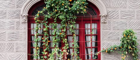 Stunning stone building with an arched window, adorned with a lush vine.