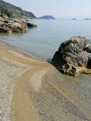 A rocky beach with clear water and distant hills. - "Philoxenia" ( Sea front apartment (Glossa Skopelos Island,)