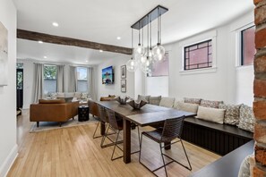 A modern dining area with a wooden table, metal chairs, and a hanging light fixture.