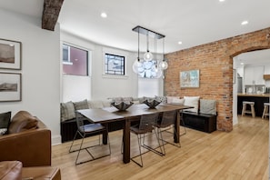 A modern living space with a dining area, kitchen, and seating area.