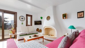Ein Wohnzimmer mit einer Couch, einem Couchtisch, einem Kamin und einem Fernseher.