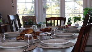 A dining table set for breakfast with plates, glasses, and a variety of food items. - Lakeview Historic Home Guest Rave: Delicious Breakfast  (Wisconsin Dells)