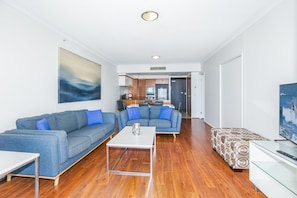 A modern living room with two sofas, a coffee table, and a TV.
