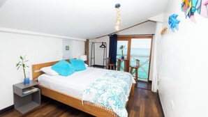 A bedroom with a wooden bed, a nightstand, a view of the sea, and a balcony with a chair. - Cristal Blue Baru (Cartagena)