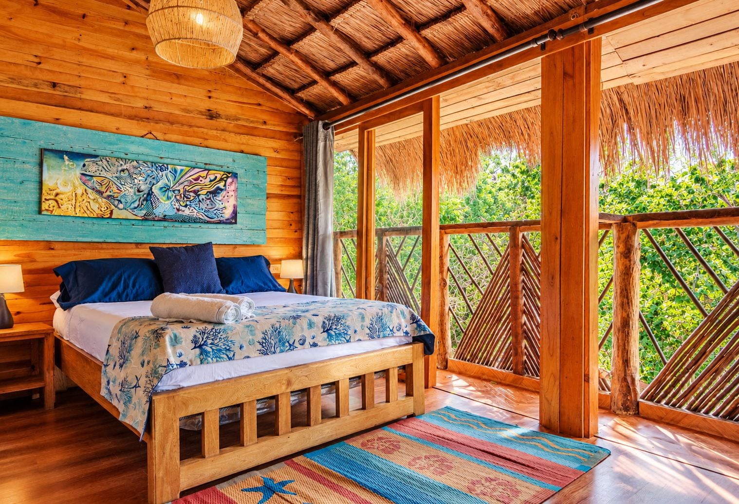 Ein Zimmer mit Holzboden, einem Bett, einem Gemälde und Blick auf Grünflächen.