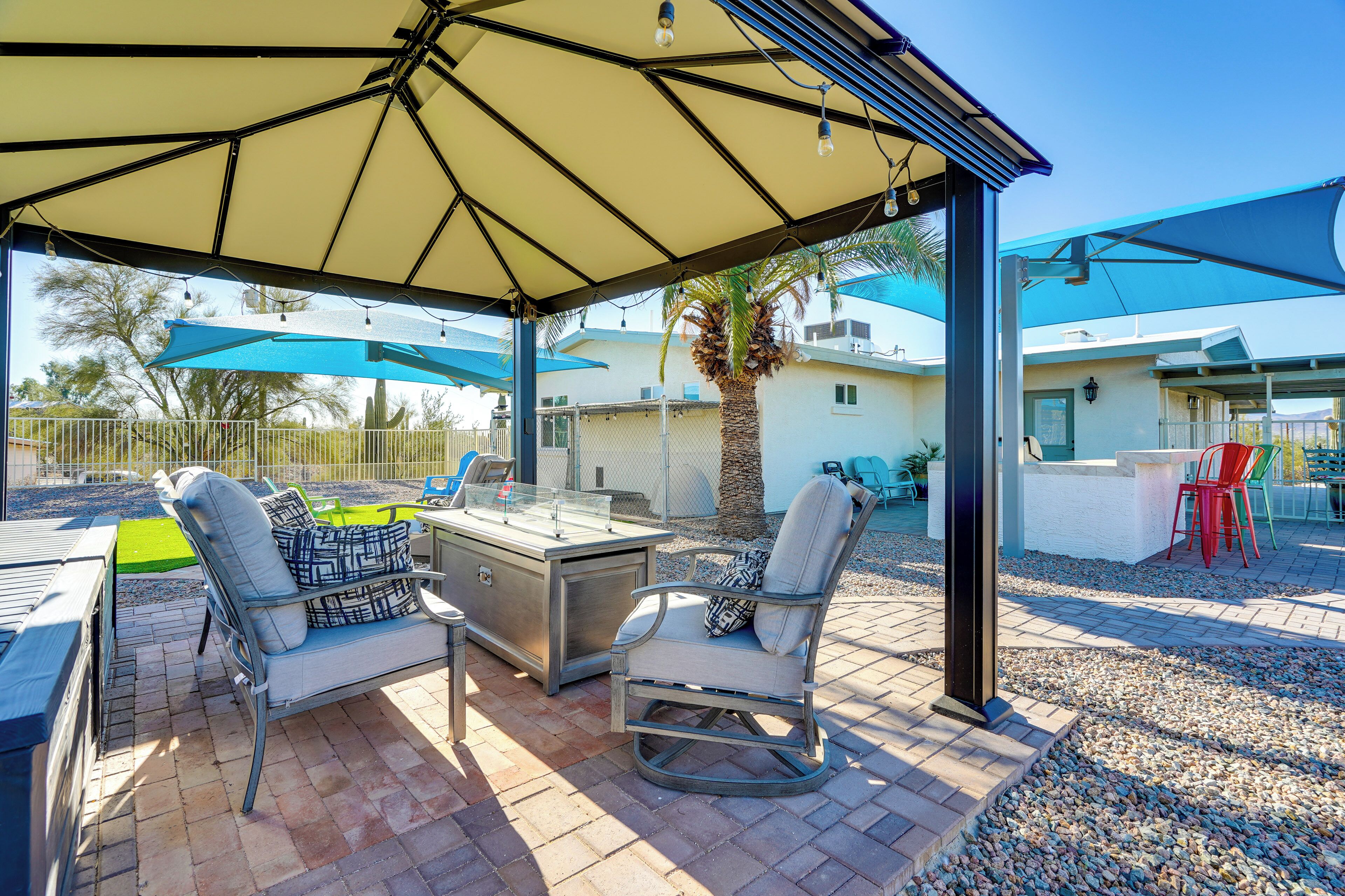 Ein Patio im Freien mit Tisch, Stühlen und Sonnenschirmen.