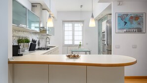 A modern kitchen with a central island, stainless steel appliances, and pendant lighting.