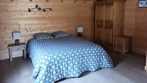 A wooden cabin bedroom with a bed, nightstands, and a wardrobe. - Les 7 Coeurs, cosy chalet in Val Foncine (Foncine-le-Haut)