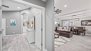 A spacious living area with a modern design, featuring a sofa, coffee table, and a dining table. - Modern Southwest home w/heated pool oasis (Peoria)