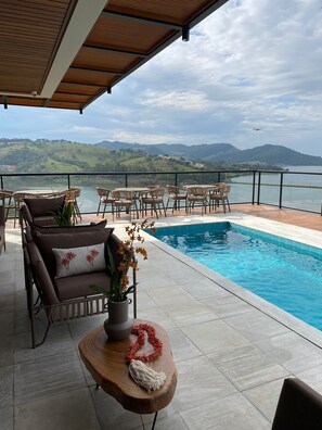 Una piscina al aire libre, sillones reclinables de piscina