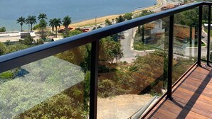 A balcony with a clear view of a lake, surrounding hills, and a distant shoreline. - Vista do Lago Hotel (Capitólio)