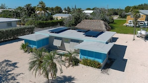 Un bâtiment doté d’un toit plat, de panneaux solaires et d’une piscine.