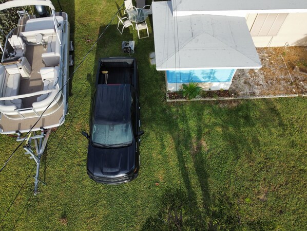 A boat docked at a house with a covered outdoor seating area and a small pool. - Pet Friendly Half-Duplex Cottage with kayaks and 40' Slip Option at Marina (Marathon)