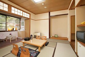 A traditional Japanese-style room with tatami flooring, a low table, and sliding doors.
