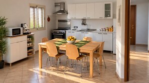 Una cucina moderna con tavolo, sedie e fornello.