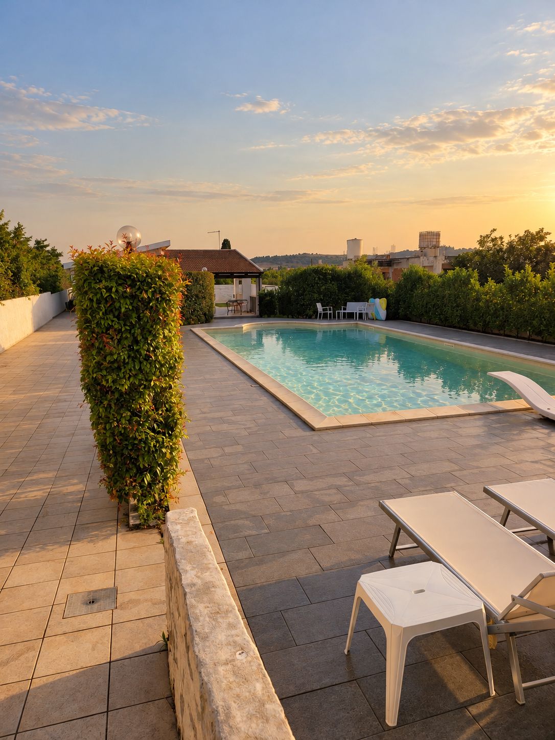 Ein Dachpool mit Liegestühlen und einem kleinen Gebäude im Hintergrund.