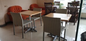 Un coin repas avec une table et des chaises, un canapé et une plante en pot.