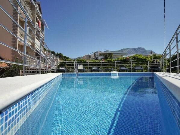 Kauden mukainen ulkouima-allas, aurinkotuoleja