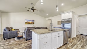 A modern kitchen with white cabinets, a stainless steel refrigerator, and a granite countertop. - Comfortable New Home in Broadmoor Subdivision (Twin Falls)