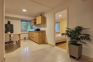 Eine moderne Küche mit Holzausstattung, einem Essbereich mit Tisch und Stühlen sowie einem Blumentopf.