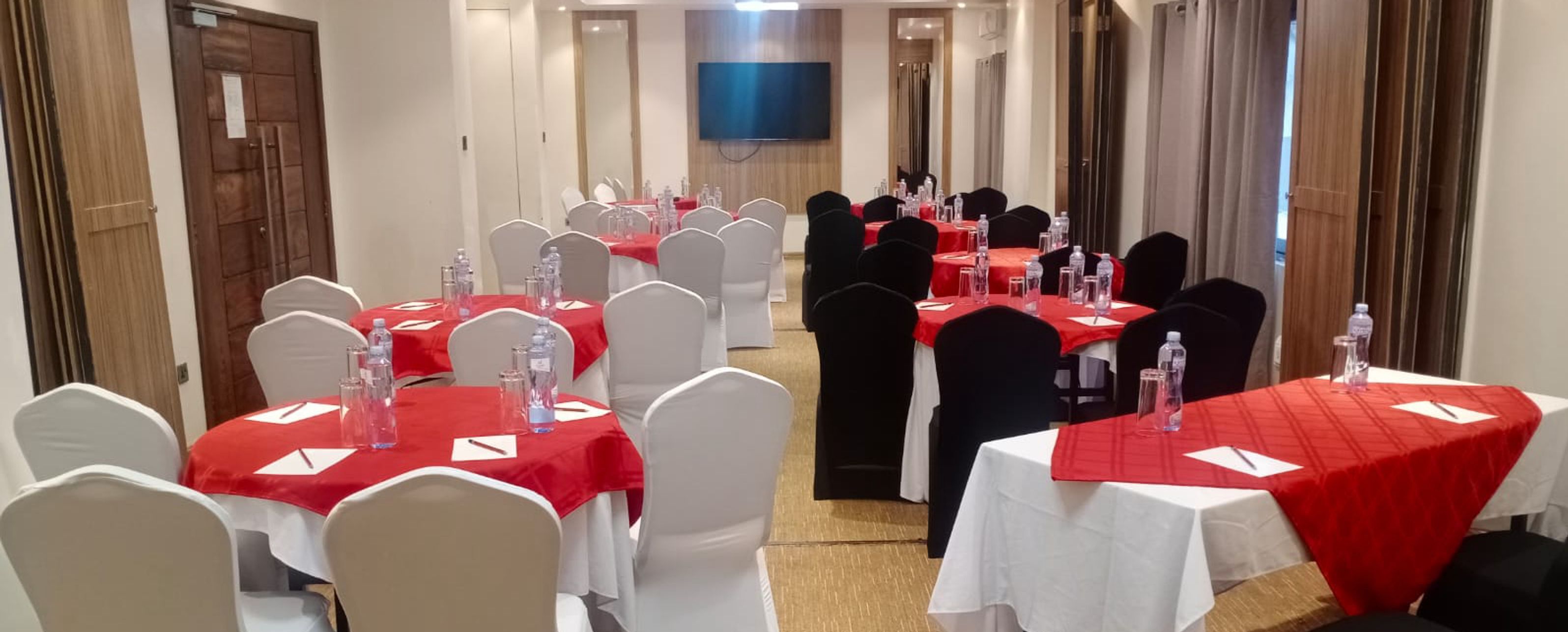 A conference room with tables set for meetings, equipped with water bottles and name cards.