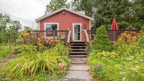 A red house with a front porch and a wooden fence. - Inn at High Falls (High Falls)