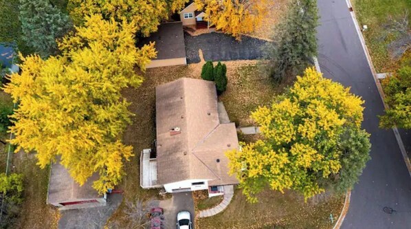 Situated in a suburban area, this single-story house features a driveway and a car.