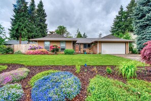 A two-story house with a front yard, a garage, and a driveway.