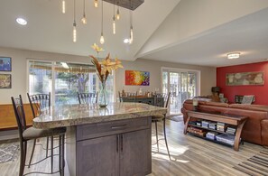 A spacious kitchen with a central island, dining area with chairs, a sofa, and a bookshelf. - Close to Downtown*Luxe-Beautiful Shower-Pets! (Vancouver)