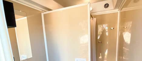 Un baño pequeño con inodoro, lavamanos y espejo.