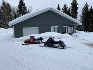 En sneboldsparket foran et hus med garage.