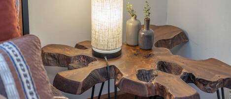 A wooden table with a woven lamp and two vases.