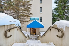 A staircase leading to a building with a sign reading "Pinnacle Spa & Lounge". - Pinnacle F07 (Killington)