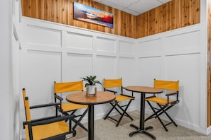 A conference room with a round table, four yellow chairs, and a potted plant. - Pinnacle F07 (Killington)