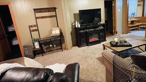 Una sala de estar con televisión, chimenea y comedor.