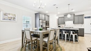 A modern kitchen with a central island, stainless steel appliances, and pendant lighting. - BeachView-Arcade-Walk to Beach-Restaurants-Casino (Gulfport)