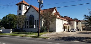 A church with a bell tower, a parking lot, and a clear blue sky. - Quirky historic home, fully renovated! Designer interior! Plush linens! Firepit! (New Iberia)