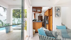 A modern kitchen with wooden cabinets, a built-in refrigerator, and a countertop with a sink. - Private villa with pool, enjoy the Dominican Caribbean. (Cabarete)
