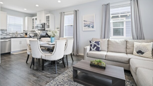 A modern living room with a sofa, coffee table, and dining area. - Silver Strand Beach Bungalow (Imperial Beach)