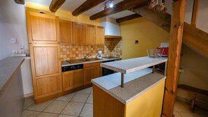 A kitchen with wooden cabinets, a tiled backsplash, and a granite countertop. - Gîtes de France 6 people in Le Teil (ALBARET LE COMTAL)