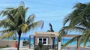 A small, single-story building with a flat roof, a central entrance, and a view of the ocean. - Seamist Holiday home, Spectacular Mountain View, walk to pool gym restaurant (Lucea)