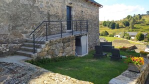 Un bâtiment en pierre avec un escalier menant à un balcon.