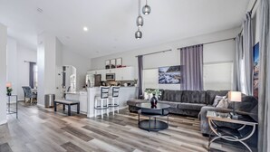 A modern living room with a sofa, coffee table, and dining area.
