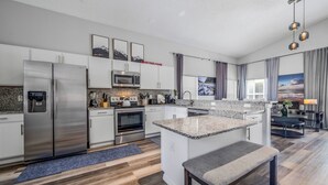 A modern kitchen with stainless steel appliances, granite countertops, and a central island.